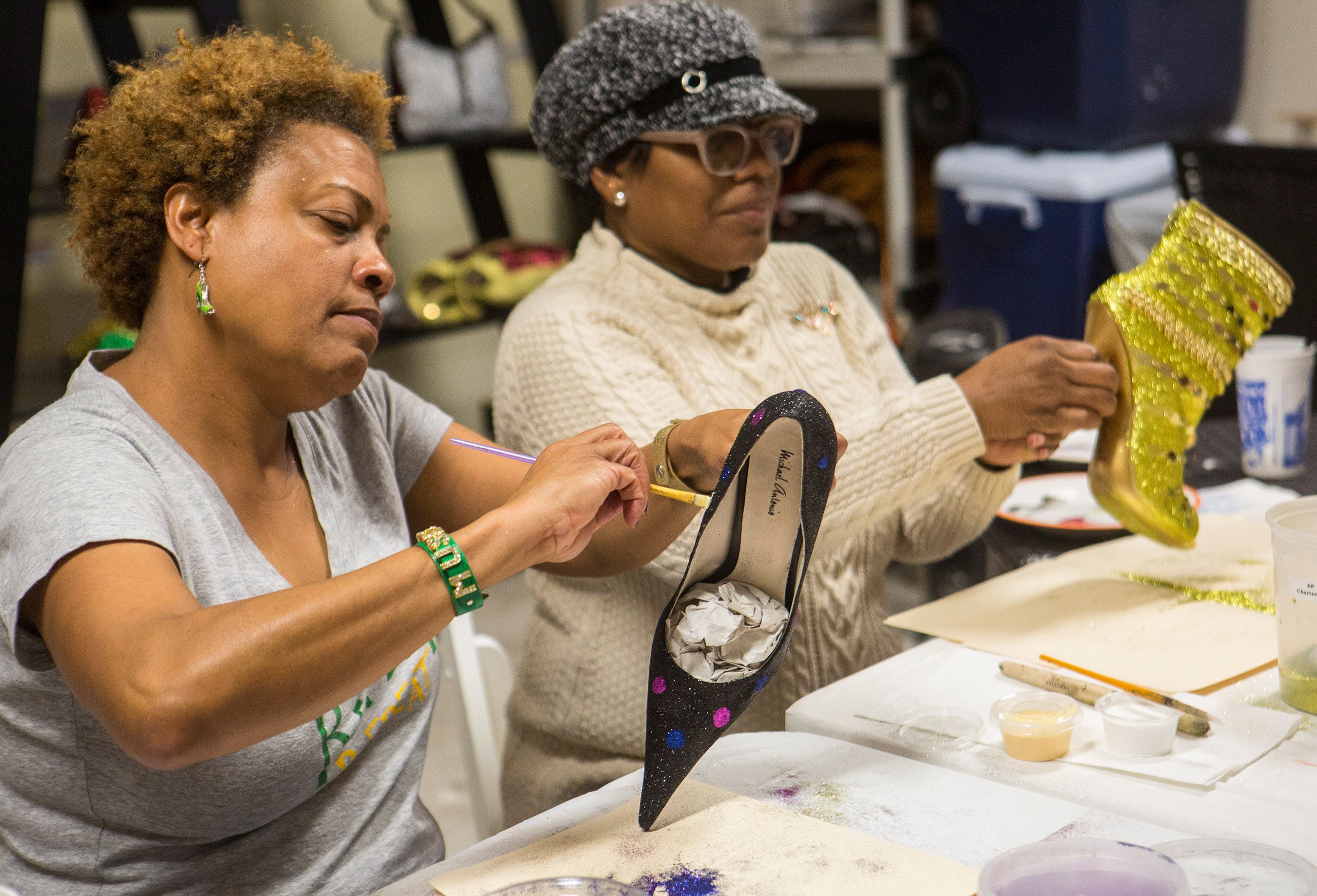 Krewe of Muses members decorating shoes to be given as throws during the parade, 2017, photograph by Mark J. Sindler