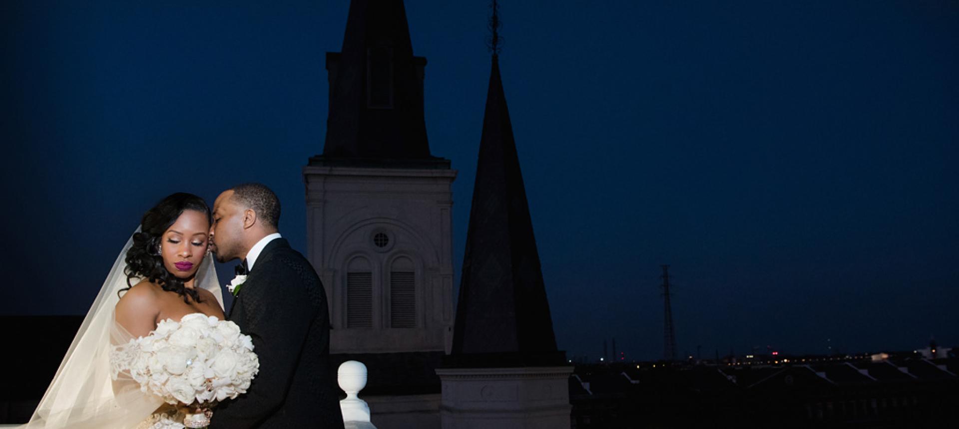 Romantic photograph of newly married couple atop the cupola of the Cabildo with St. Louis Cathedral in the background